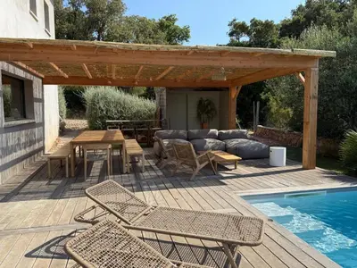 a patio with a table and chairs next to a pool at Rondinara Camara - Lecci Lodge in Lecci