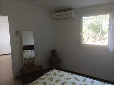a bedroom with a bed and a window and a mirror at I Caselli, mini villa Vue Mer dans résidence calme et arborée in Lecci