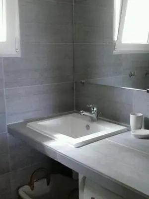 a bathroom with a white sink and a mirror at I Caselli, mini villa Vue Mer dans résidence calme et arborée in Lecci