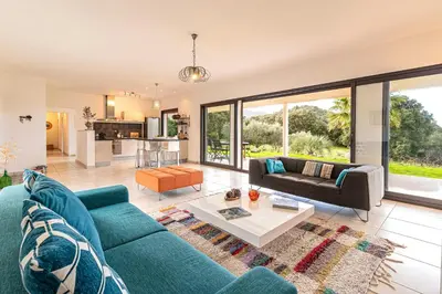 a living room with a blue couch and a table at Mare e Machja - Maison avec piscine in Cauro