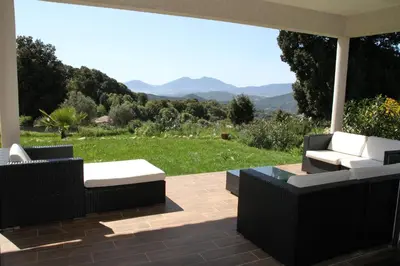 a patio with couches and a view of the mountains at Mare e Machja - Maison avec piscine in Cauro