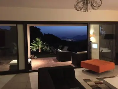 a living room with a view of the mountains at Mare e Machja - Maison avec piscine in Cauro