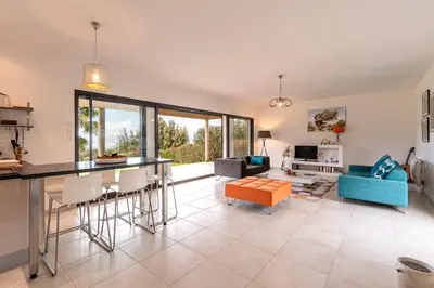a kitchen and living room with a table and chairs at Mare e Machja - Maison avec piscine in Cauro