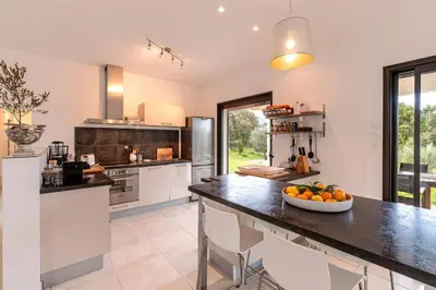 a kitchen with a table with a bowl of fruit on it at Mare e Machja - Maison avec piscine in Cauro