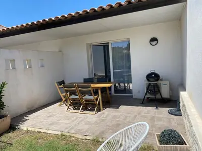 a patio with a table and chairs on a patio at Villa résidence avec piscine chauffée Bonifacio in Bonifacio