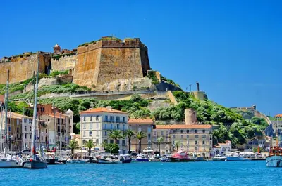 a group of boats in a harbor with a castle at Villa résidence avec piscine chauffée Bonifacio in Bonifacio