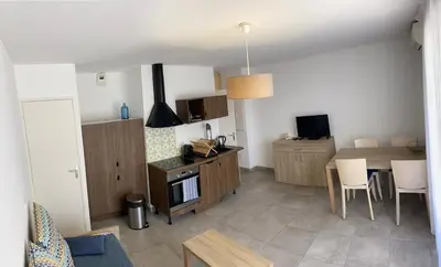 a kitchen and living room with a table and chairs at Villa résidence avec piscine chauffée Bonifacio in Bonifacio