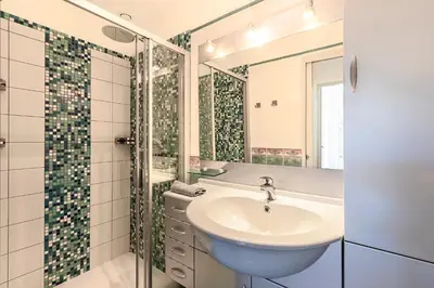 a bathroom with a sink and a shower at Casa Vinti - Vue mer et montagne climatisé in Porticcio