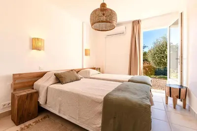 a bedroom with two beds and a large window at Casa Vinti - Vue mer et montagne climatisé in Porticcio
