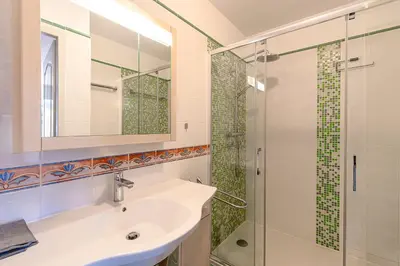 a bathroom with a sink and a shower at Casa Vinti - Vue mer et montagne climatisé in Porticcio