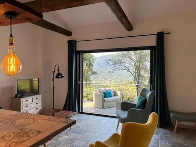 a bedroom with a sliding glass door to a patio at Casa Lesia - Mini-Villa proche des plages in Viggianello