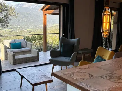 a living room with chairs and a table with a view at Casa Lesia - Mini-Villa proche des plages in Viggianello