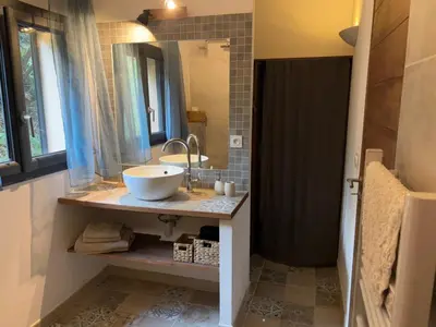 a bathroom with a sink and a large mirror at Casa Lesia - Mini-Villa proche des plages in Viggianello