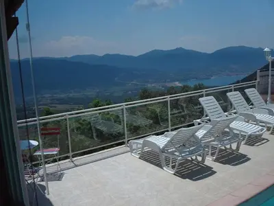 a group of chairs sitting on top of a balcony at Villa conviviale à Olmeto avec piscine privée in Olmeto