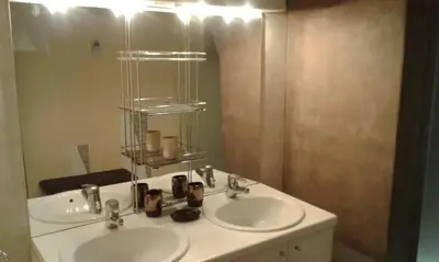 a bathroom with two sinks and a mirror at Villa conviviale à Olmeto avec piscine privée in Olmeto