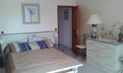 a bedroom with a white bed and a dresser at Villa conviviale à Olmeto avec piscine privée in Olmeto