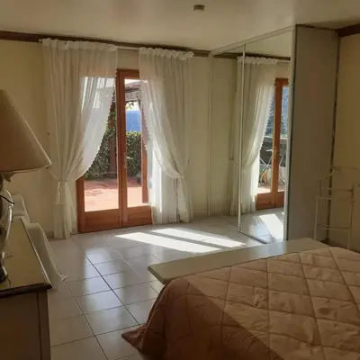 a bedroom with a bed and a large glass window at Villa conviviale à Olmeto avec piscine privée in Olmeto