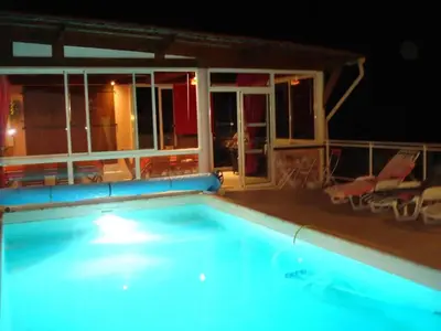a swimming pool at night with a house at Villa conviviale à Olmeto avec piscine privée in Olmeto