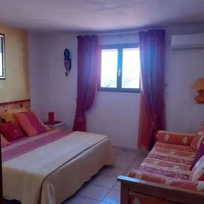 a bedroom with two beds and a window at Villa conviviale à Olmeto avec piscine privée in Olmeto