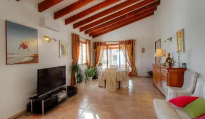 a living room with a couch and a tv and a table at Villa conviviale à Olmeto avec piscine privée in Olmeto