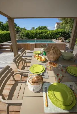 a table with plates of food on a patio at Villa Les Granges Classé 5 Étoiles in Antisanti