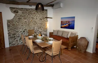 a dining room with a table and chairs and a couch at Villa Les Granges Classé 5 Étoiles in Antisanti