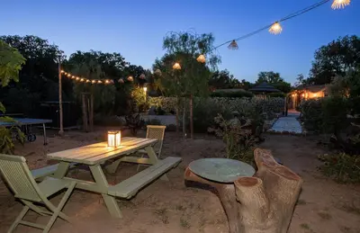 a picnic table and chairs in a backyard at night at Villa Les Granges Classé 5 Étoiles in Antisanti