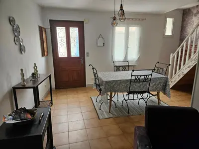 a living room with a table and chairs and a door at Casa di JF in Olmeta-di-Tuda