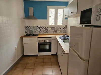 a small kitchen with white appliances and blue walls at Casa di JF in Olmeta-di-Tuda