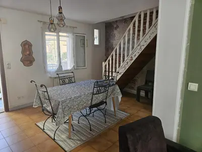 a dining room with a table and chairs and a staircase at Casa di JF in Olmeta-di-Tuda