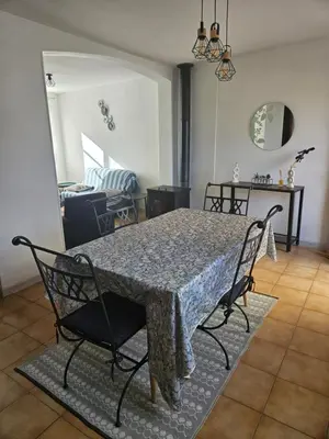 a dining table and chairs in a living room at Casa di JF in Olmeta-di-Tuda