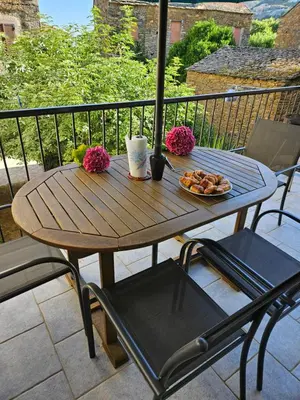 a wooden table with a plate of food on a balcony at Casa di JF in Olmeta-di-Tuda