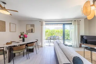 a living room with a couch and a table and chairs at VILLA BAIA 4-5 pers - 2mn plages - Kids Friendly - Clim - Piscine in Lecci