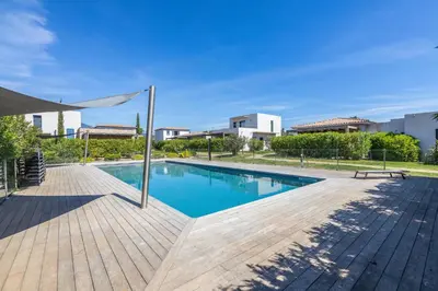 a swimming pool with a wooden deck and a bench at VILLA BAIA 4-5 pers - 2mn plages - Kids Friendly - Clim - Piscine in Lecci