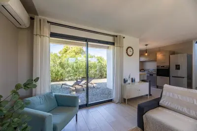a living room with a couch and a sliding glass door at VILLA BAIA 4-5 pers - 2mn plages - Kids Friendly - Clim - Piscine in Lecci