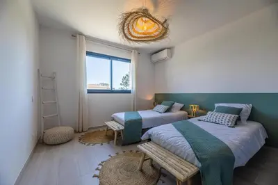a bedroom with two beds and a bench in it at VILLA BAIA 4-5 pers - 2mn plages - Kids Friendly - Clim - Piscine in Lecci