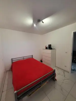 a bedroom with a bed with a red blanket at Solenzara T2 rez de villa, vue mer, proximité plage et village in Sari Solenzara