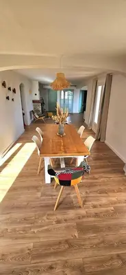 a dining room with a wooden table and chairs at Spacieux haut de villa 3 chambres Venaco in Venaco