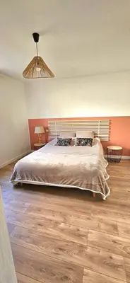 a bedroom with a large bed and a wooden floor at Spacieux haut de villa 3 chambres Venaco in Venaco