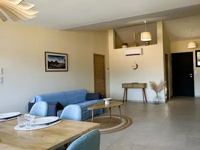 a living room with a blue couch and a table at Superbe vue Mer et Montagne - T3 - 5mn des plages in Propriano