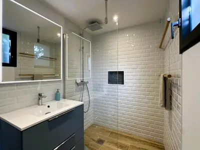 a bathroom with a sink and a glass shower at Superbe vue Mer et Montagne - T3 - 5mn des plages in Propriano
