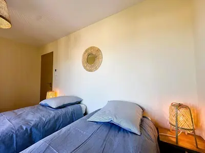 a bedroom with two beds and a mirror on the wall at Superbe vue Mer et Montagne - T3 - 5mn des plages in Propriano