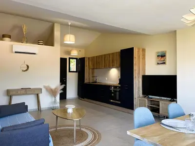 a living room with a couch and a table at Superbe vue Mer et Montagne - T3 - 5mn des plages in Propriano