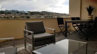 a room with a chair and a table with a view at PORTICCIO Appart 6pers Climatisé proche plage in Porticcio