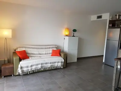 a living room with a couch with red pillows at PORTICCIO Appart 6pers Climatisé proche plage in Porticcio