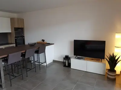 a kitchen with a television and a table with stools at PORTICCIO Appart 6pers Climatisé proche plage in Porticcio