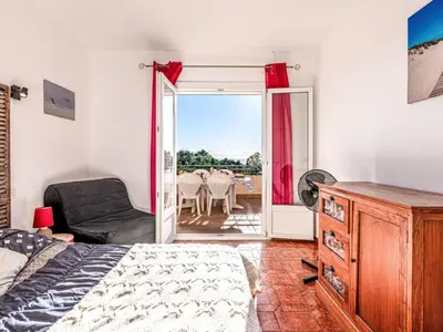 a bedroom with a bed and a chair and a table at Apartment T3 Gabriello by Interhome in Cala dʼOro