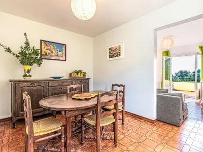 a dining room with a wooden table and chairs at Apartment T3 Gabriello by Interhome in Cala dʼOro