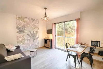 a living room with a couch and a table at Beau studio Routes des Sanguinaires proche de la plage in Ajaccio