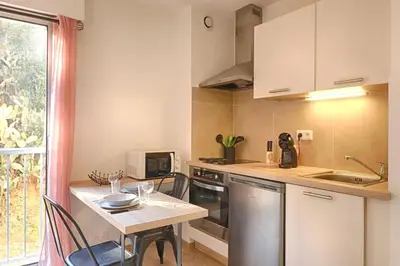 a small kitchen with a table and a counter top at Beau studio Routes des Sanguinaires proche de la plage in Ajaccio